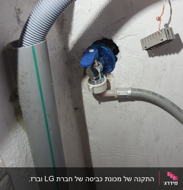 ברז כחול עם צינור אפור על קיר לבן